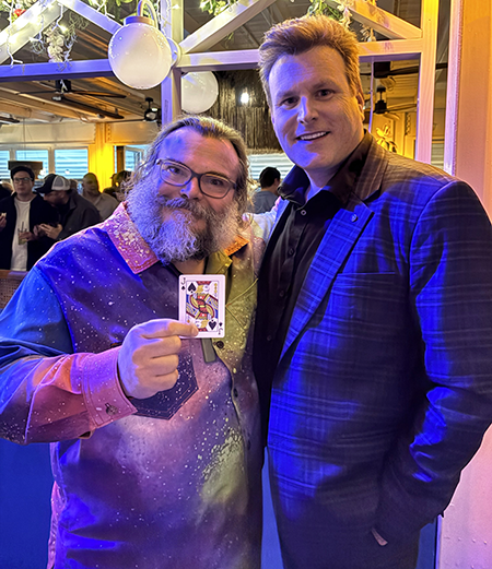 Picture of Waikato Magician Mick Peck with Jack Black performing magic tricks at a party